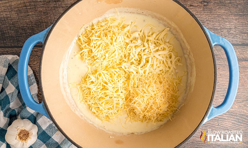 adding shredded cheeses to pot