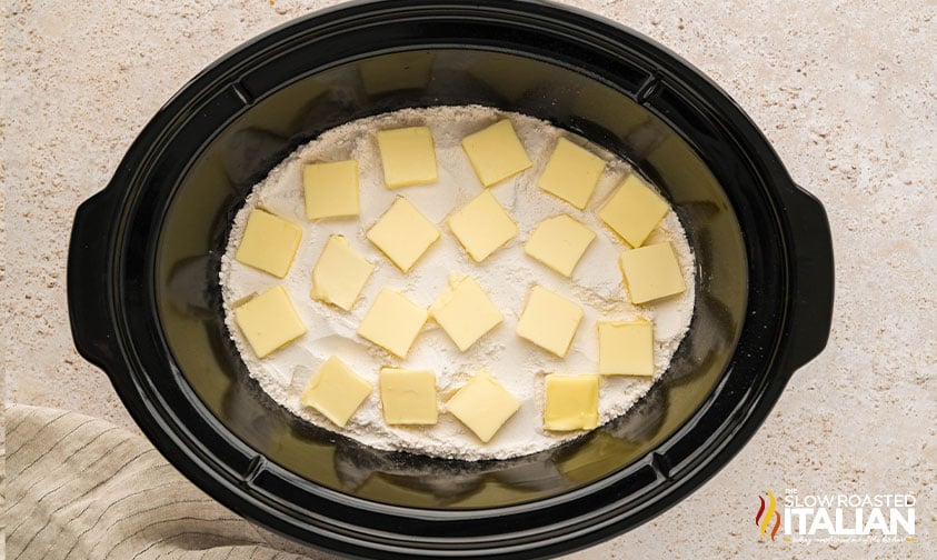 dry cake mix and butter added to apple pie filling in crockpot