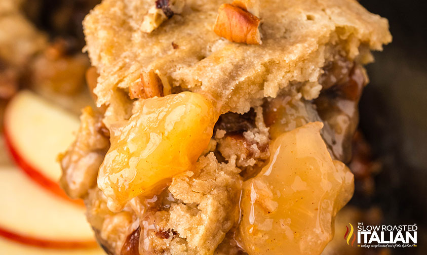 closeup of crockpot caramel apple dump cake on a serving spoon