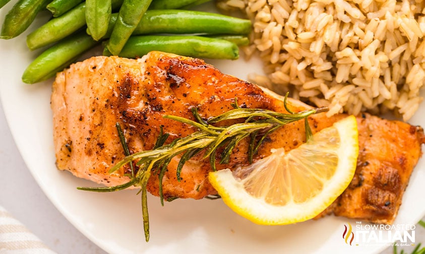 cast iron skillet salmon with brown rice and green beans on a white plate