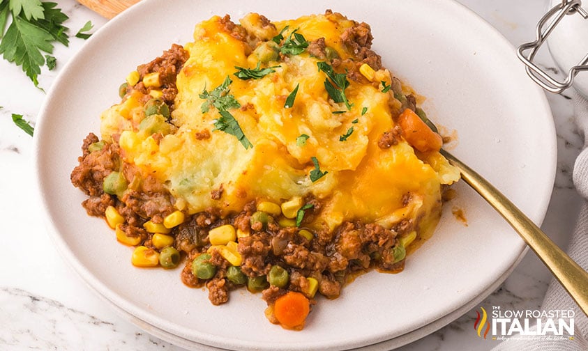 closeup of slow cooker cottage pie on a white plate with a fork