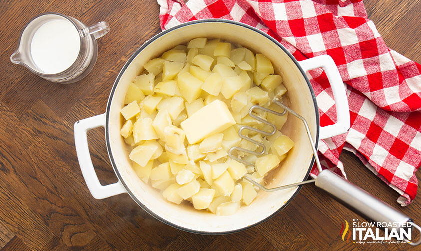 butter added to potatoes in a large pot