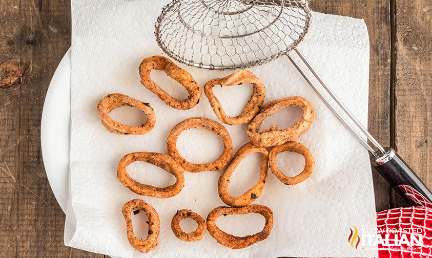 fried calamari on a paper towel lined plate