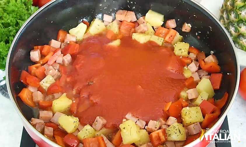 adding tomato sauce to hawaiian pasta