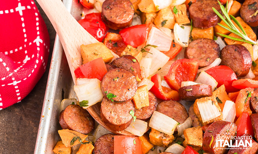 wooden spoon serving sheet pan sausage and veggies