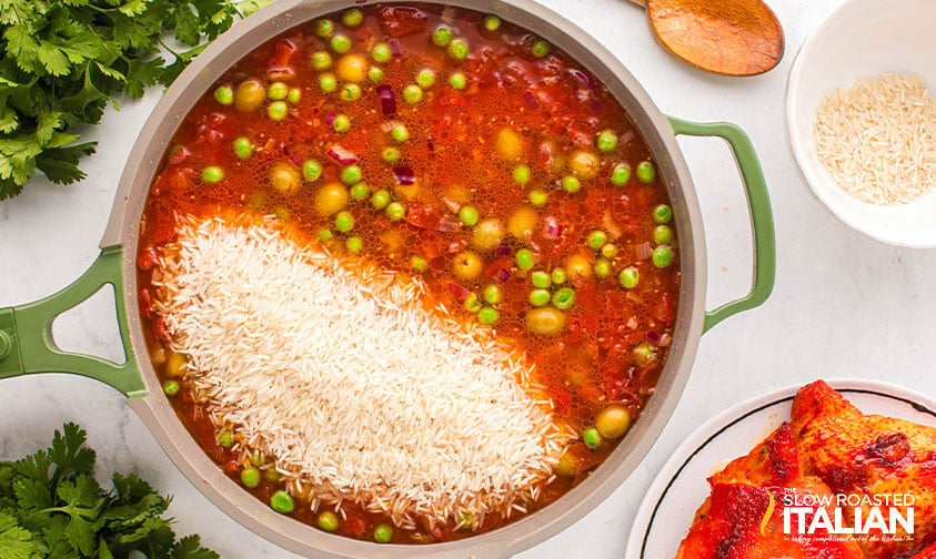 adding rice to spanish chicken in skillet