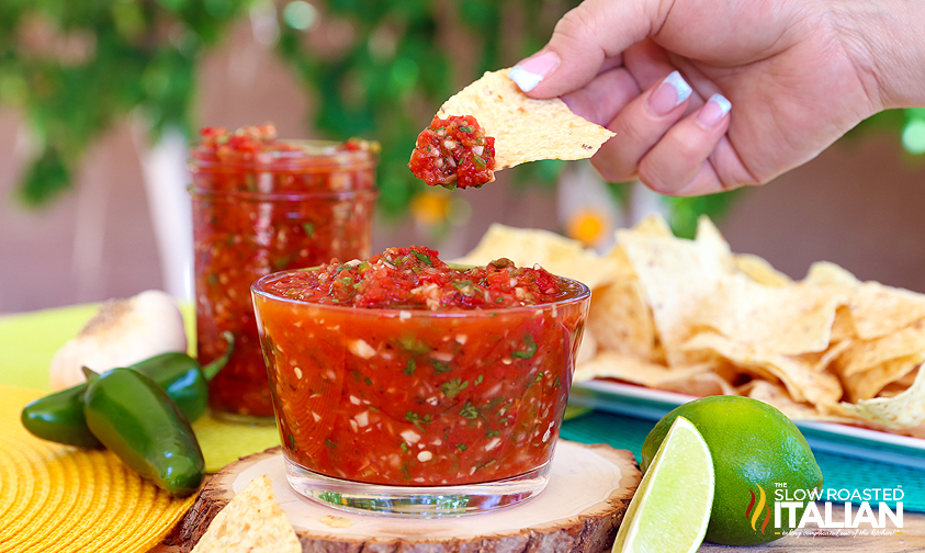 dipping a tortilla chip in 5 minute fire roasted salsa