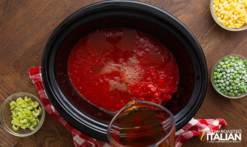 adding diced tomatoes, crushed tomatoes and stock to crock pot