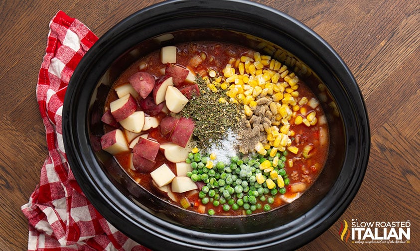 adding potatoes, corn, peas, and seasoning to crockpot