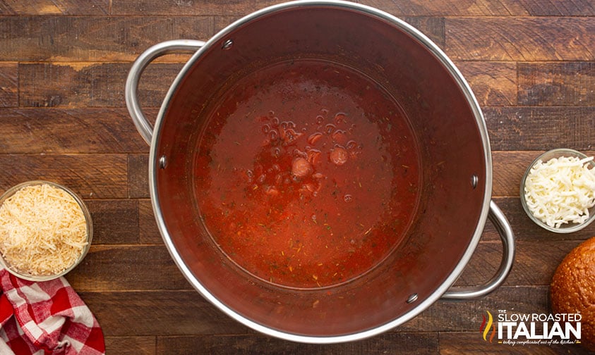 adding ingredients for pepperoni soup to a large pot