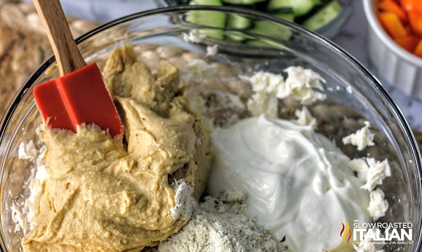 mixing cream cheese and seasoning in a bowl for veggie pizza