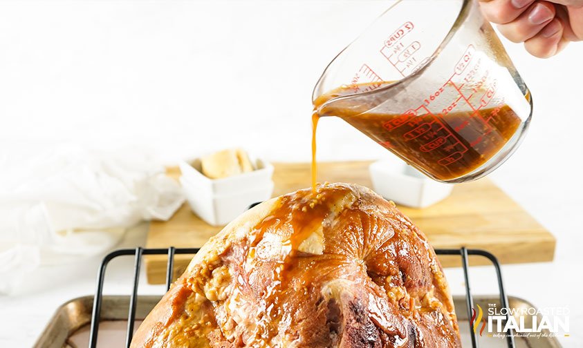 pouring glaze over halfway baked ham