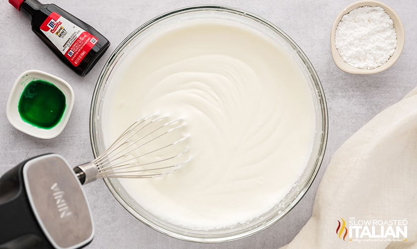 whipped heavy cream with powdered sugar in a large mixing bowl