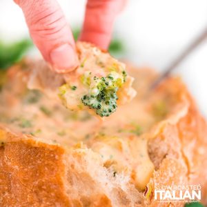 closeup of bread dipped in panera broccoli cheddar soup