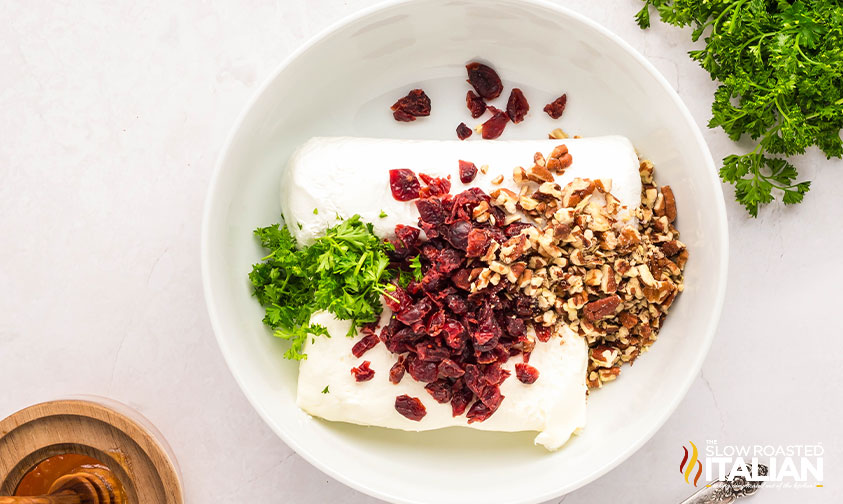 goat cheese, cream cheese, cranberries, pecans and parsley in a mixing bowl