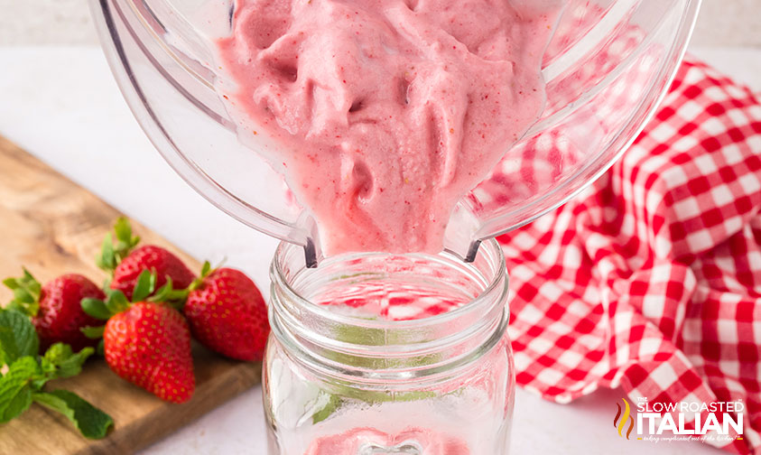 pouring strawberry milkshake in a glass