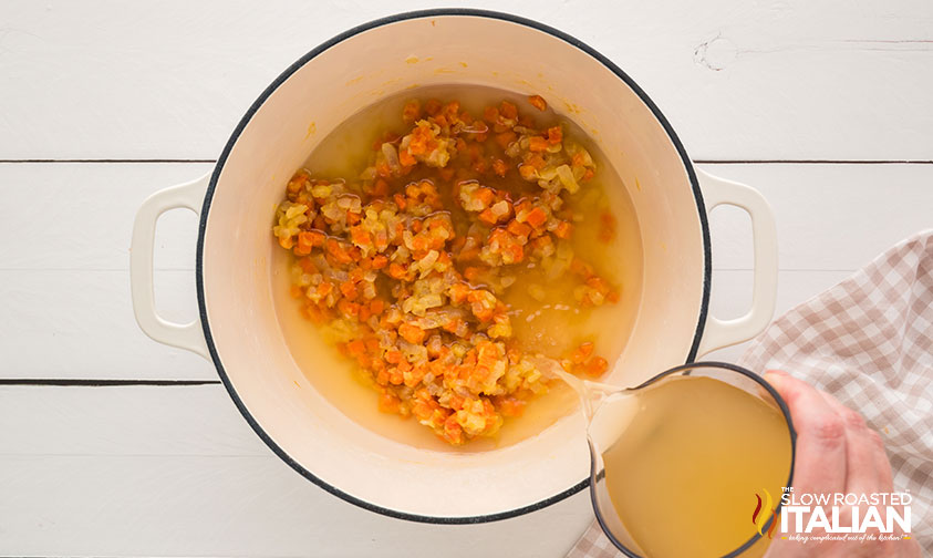 adding chicken stock to large pot