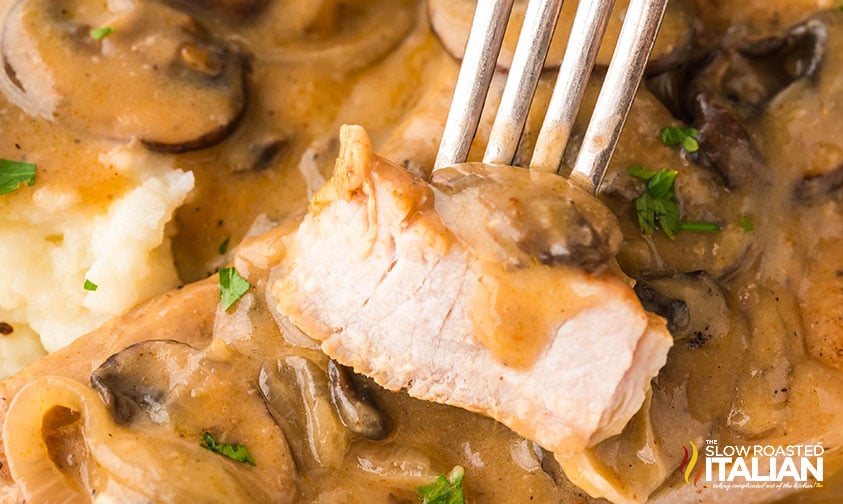 closeup of a bite of slow cooker pork chops with mushroom soup