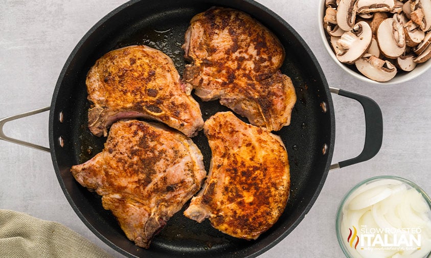 searing pork chops in a skillet