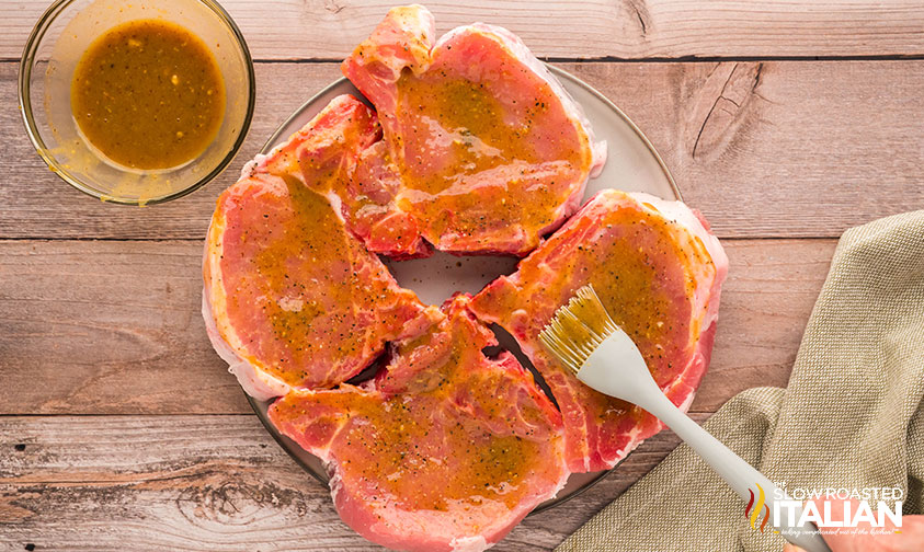 adding seasoning to pork chops