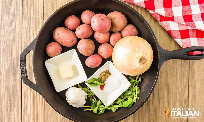 red potatoes, onion, herbs, and spices in cast iron skillet